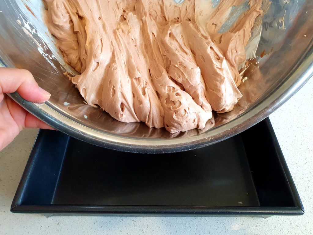 Scraping ice cream mix into pan