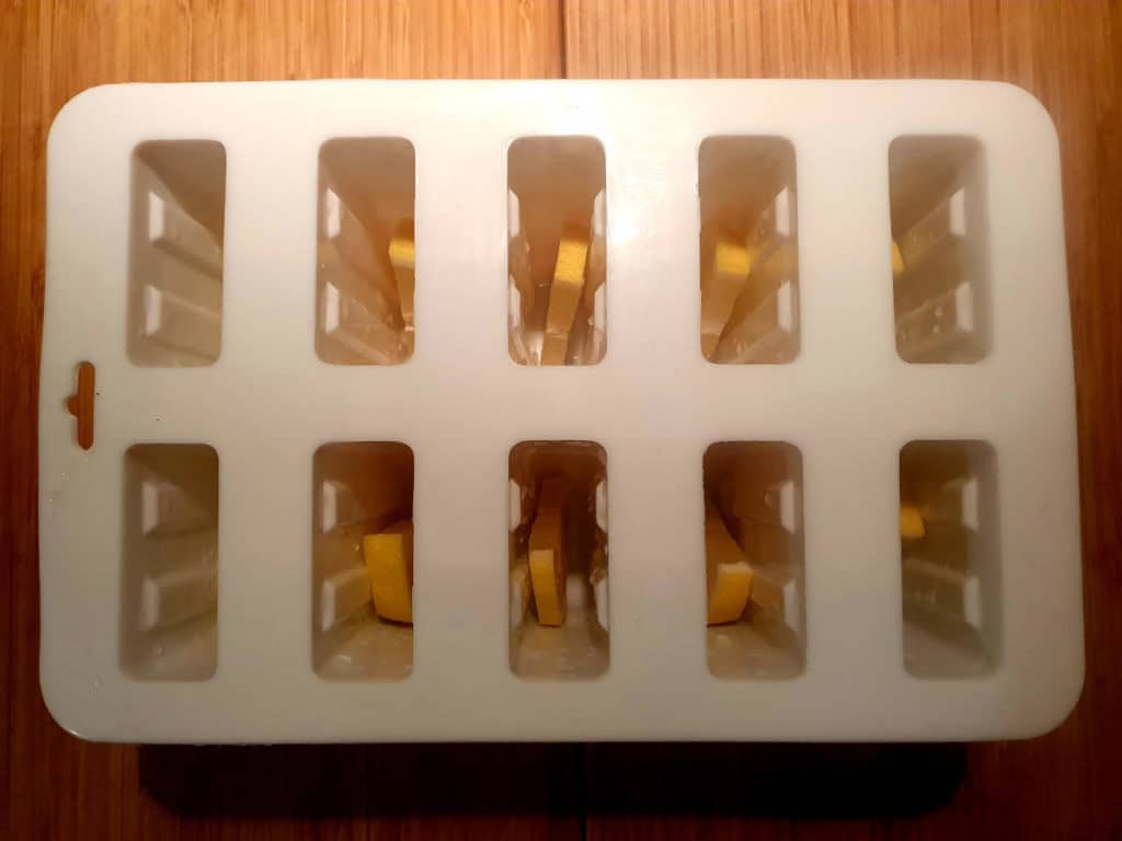 Adding lemon slices to popsicle moulds