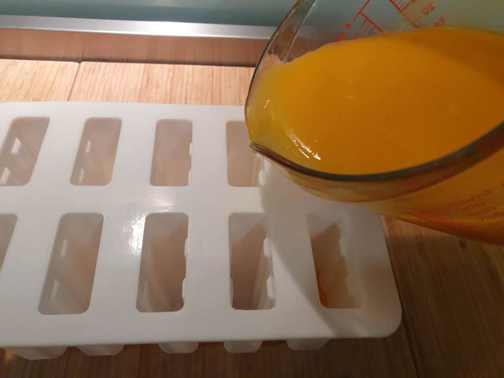Pouring mango mix into moulds