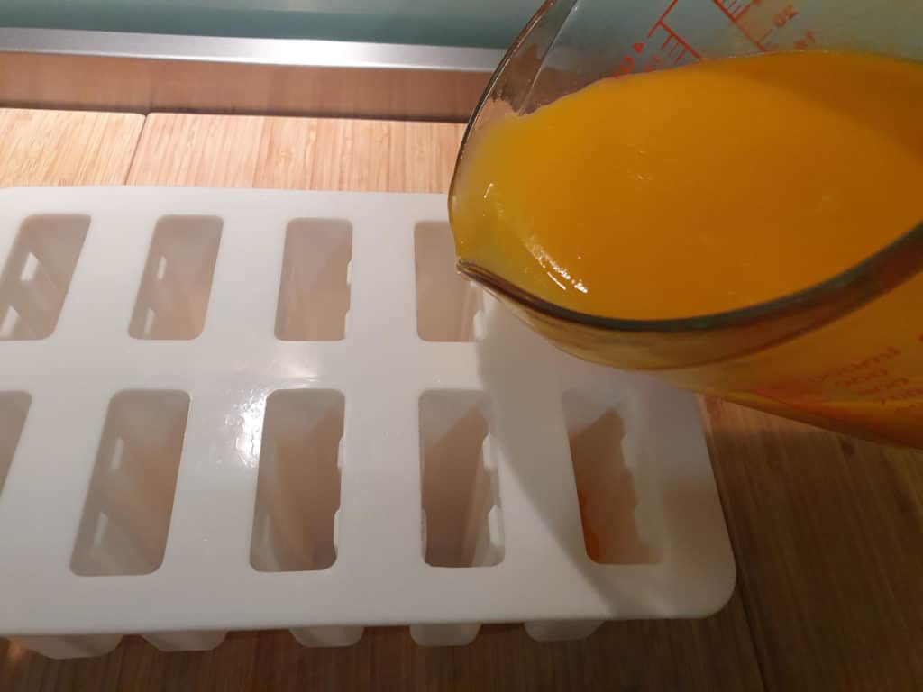 Mango coconut popsicles 6 Pouring mango mix into moulds