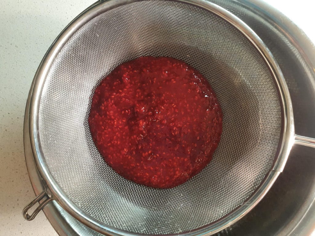 Straining raspberry mix