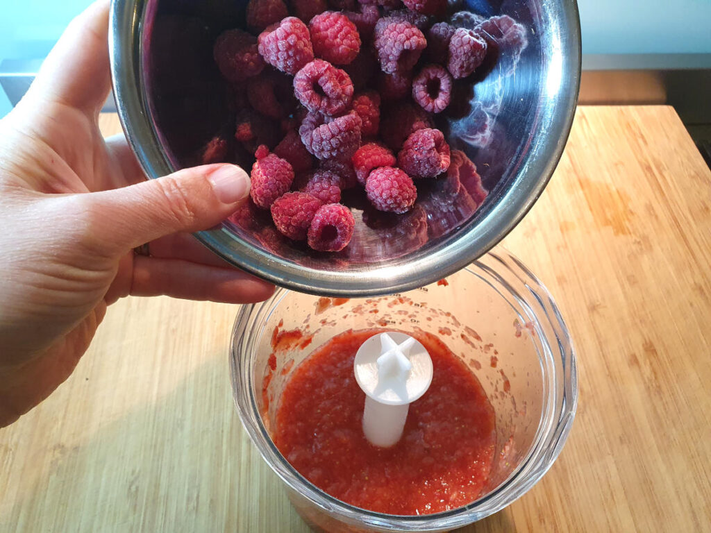 Adding raspberries to blended strawberries