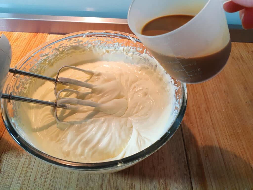 starting to add coffee to whipped cream