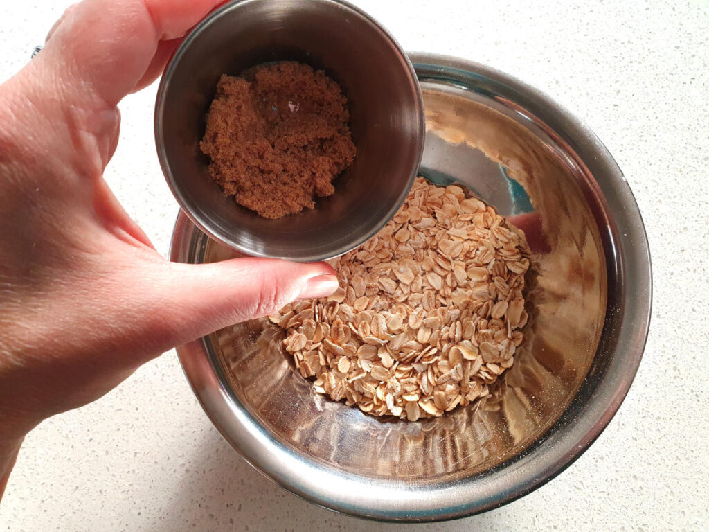 adding brown sugar to oat topping