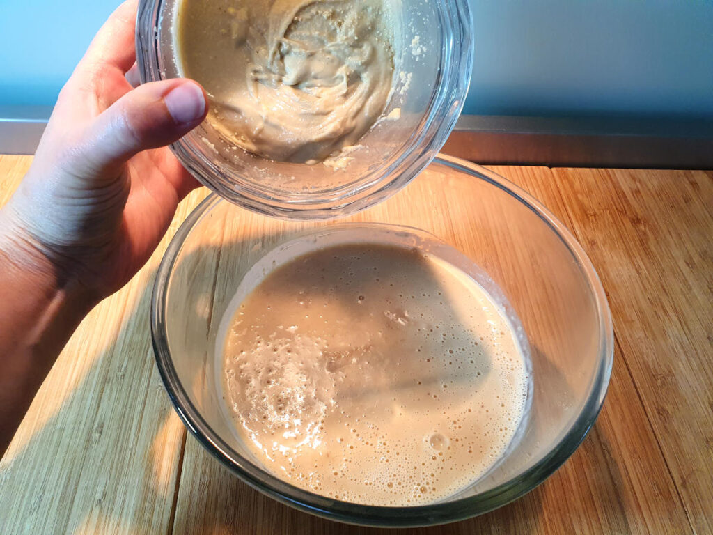 adding cashew butter to strained oat mix