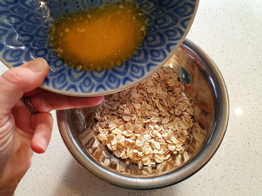 adding melted spread to oat topping