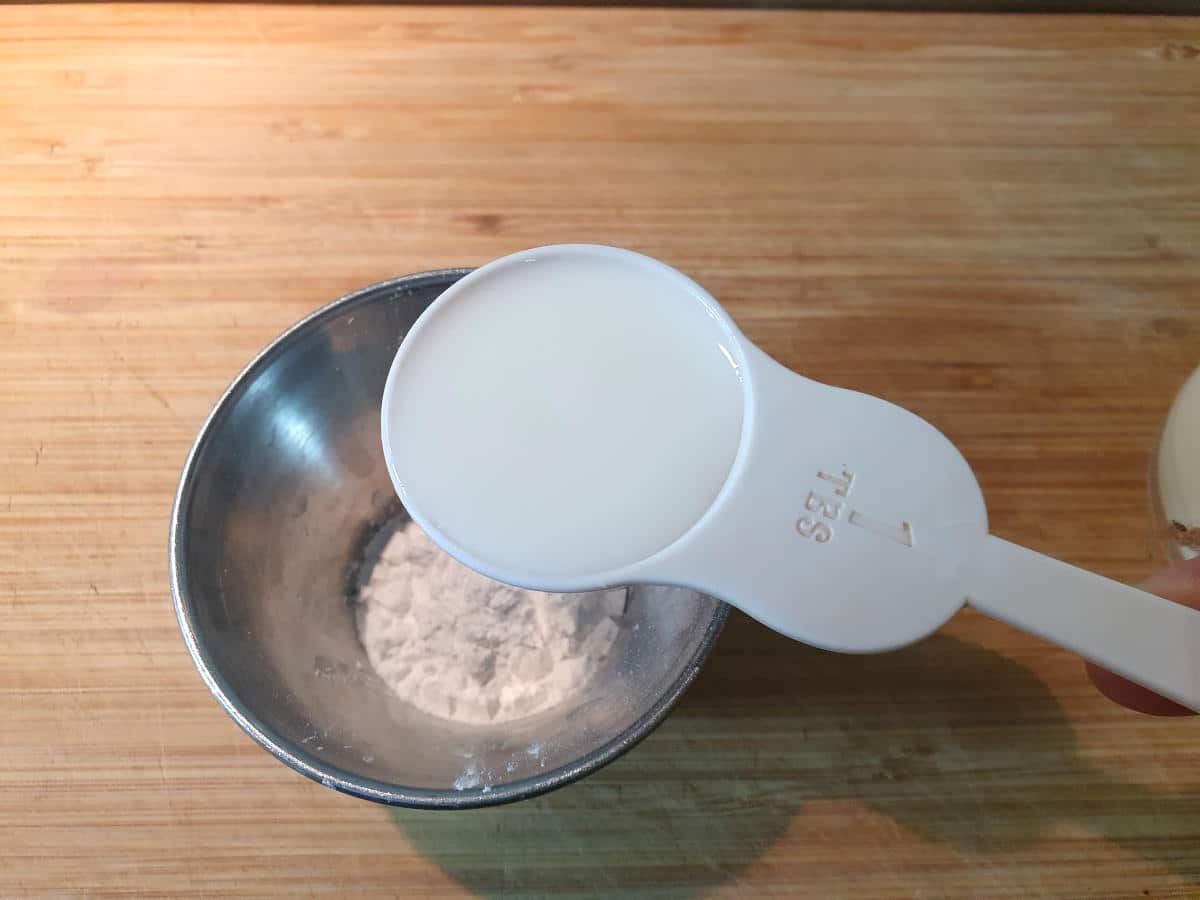 Measuring milk into the bowl.