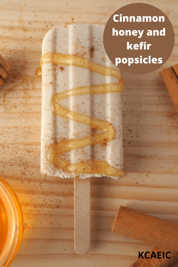 Single cinnamon, honey and kefir popsicle with honey drizzle, cinnamon sprinkle, cinnamon stick on chopping board