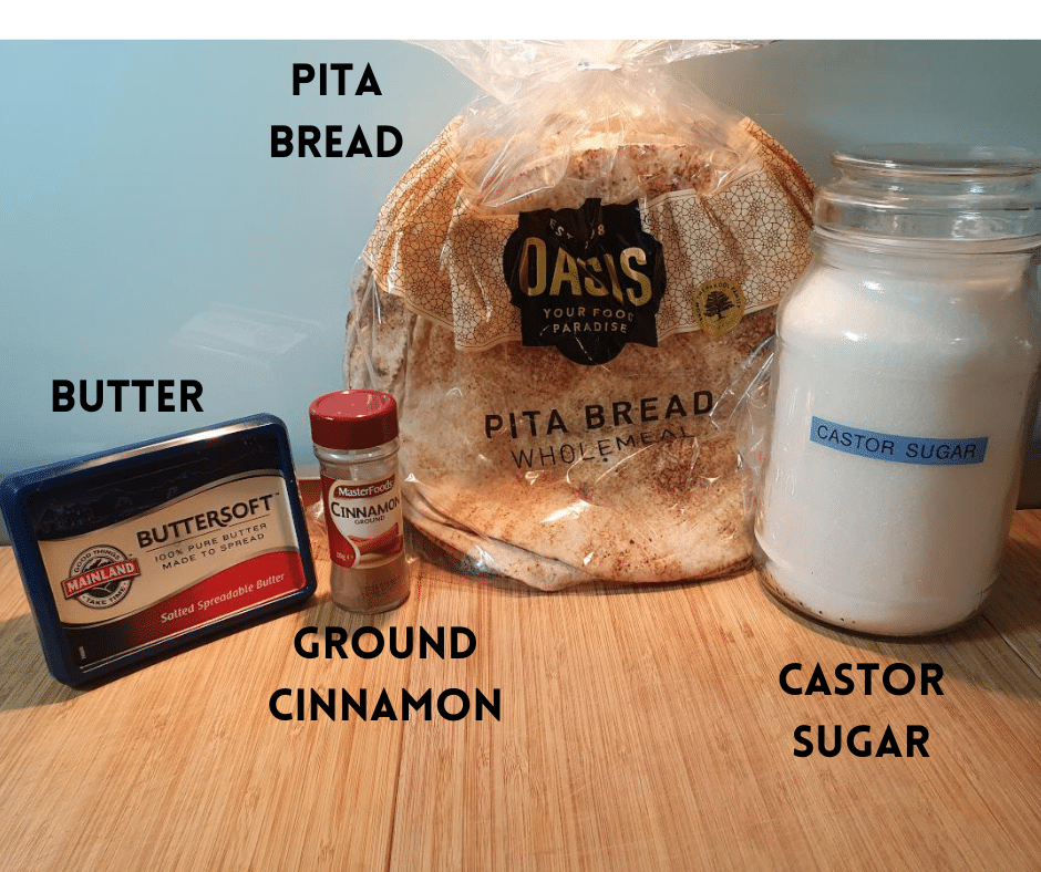 Pita chips ingredients on a chopping board, butter, ground cinnamon, pita bread and castor sugar, side view.