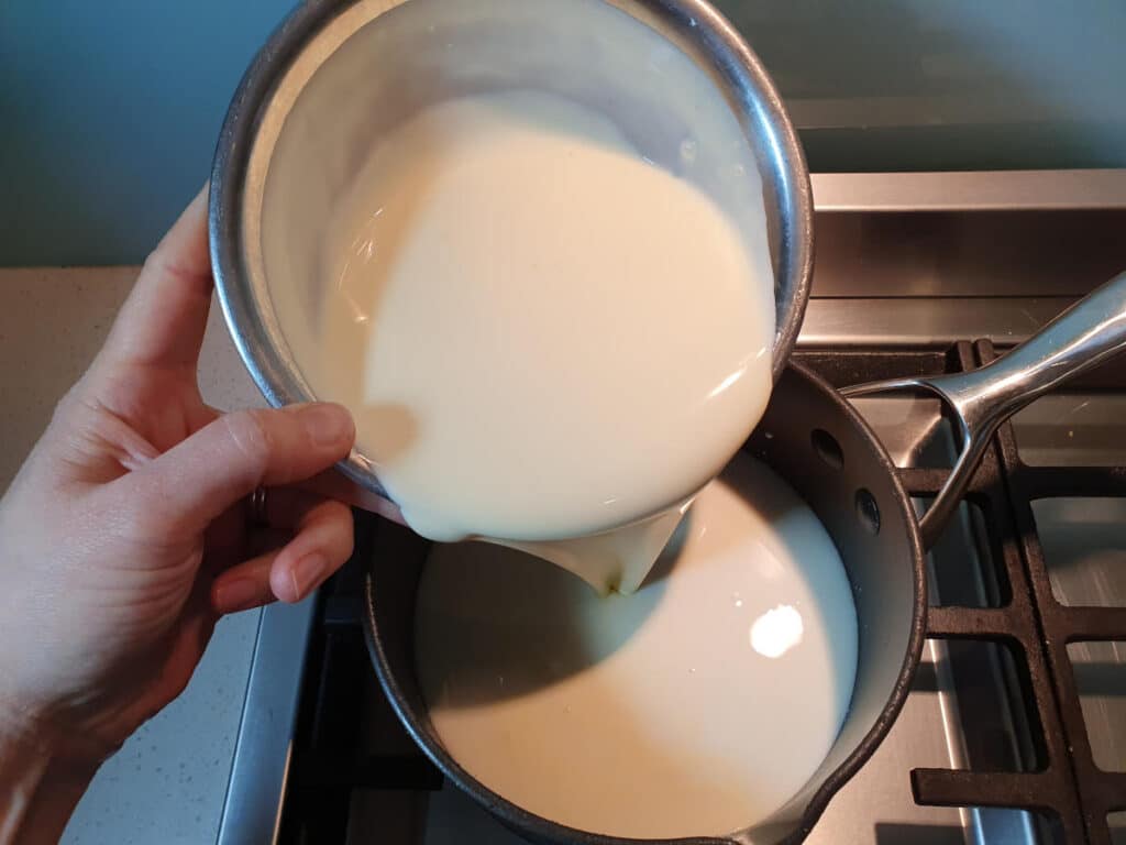 Adding cream to pot.