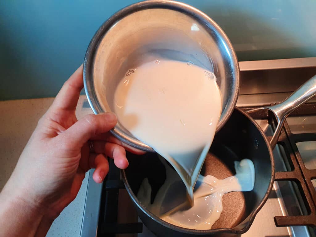 Adding milk to pot.