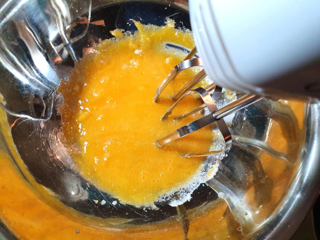 Bright yellow egg yokes and sugar just started mixing