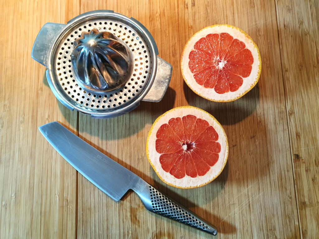 ruby grapefruit on board with knife and juicer ready to juice