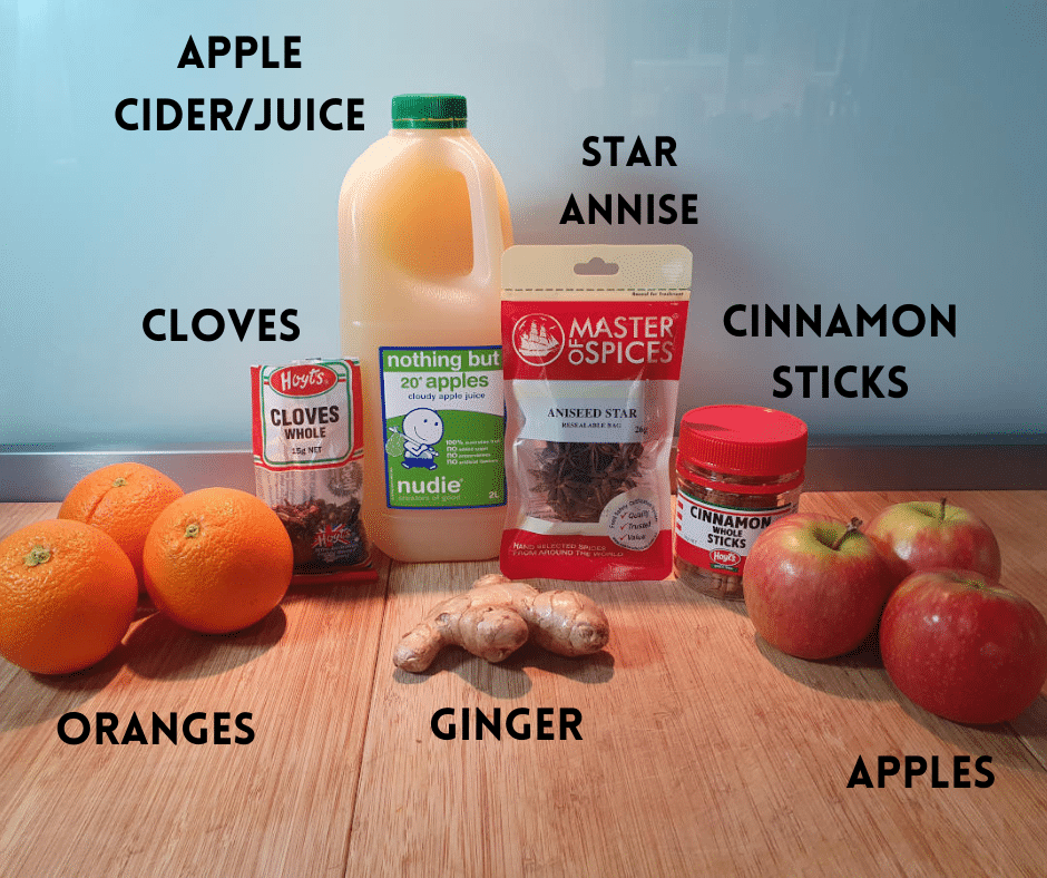 Mulled apple cider ingredients, oranges, whole cloves, ginger root, apple cider or juice, whole star annise, cinnamon sticks and apples.