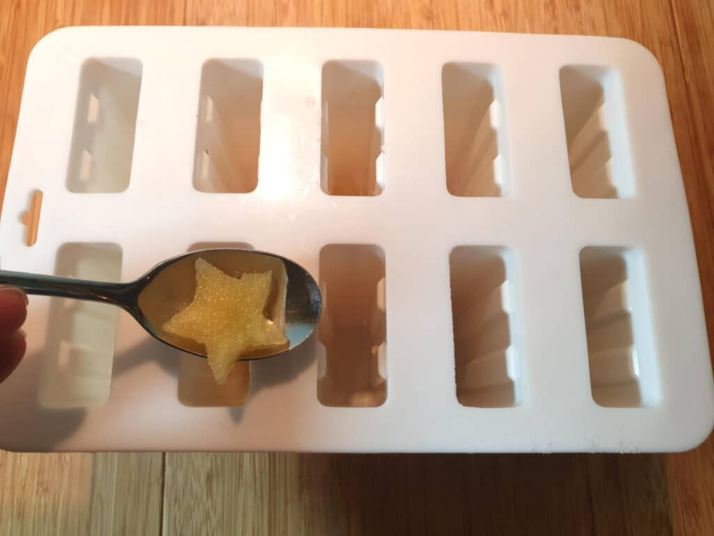 Adding apple stars to popsicle moulds.