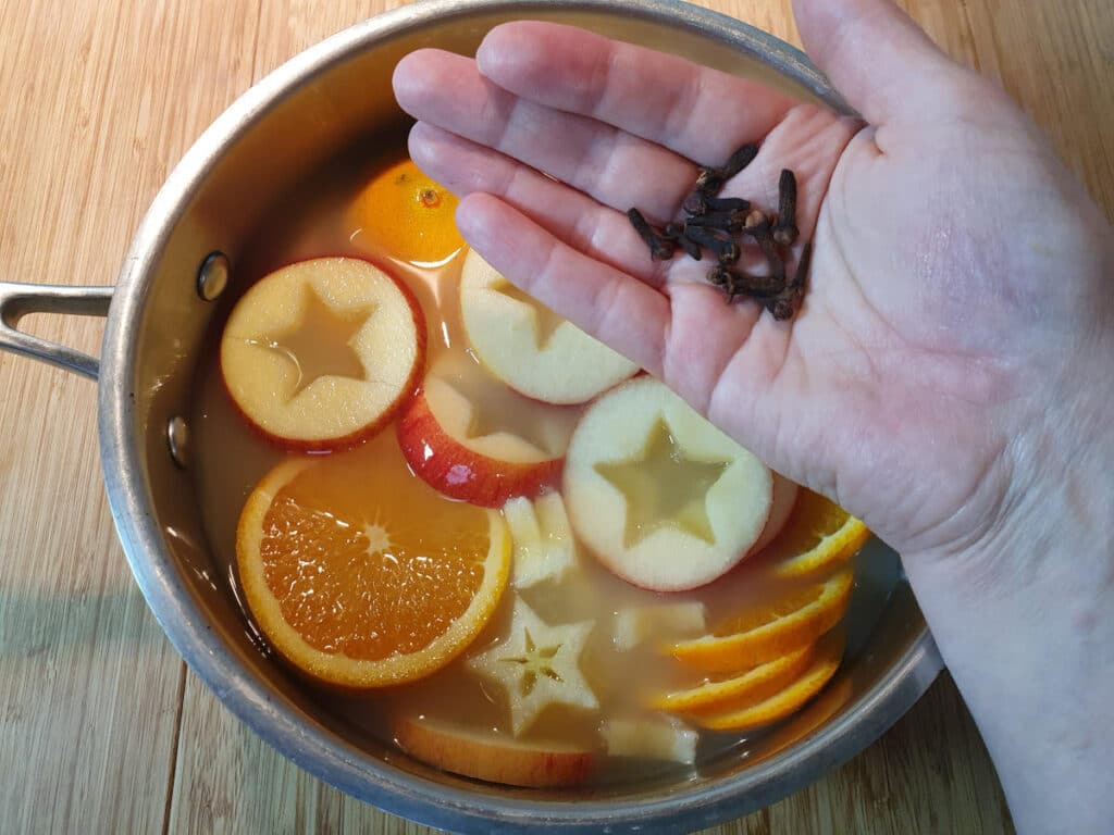 Adding whole cloves to the pot.