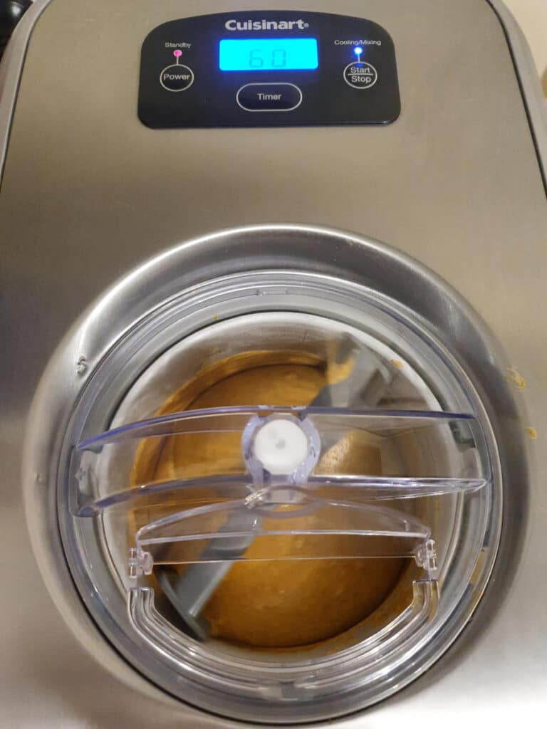 Pumpkin spice ice cream 25 top down view if ice cream churning in ice cream churner.