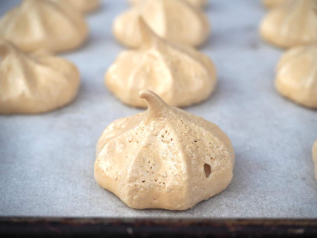 Coffee aquafaba meringues 15 side view of coffee vegan meringues on a baking tray with baking paper.