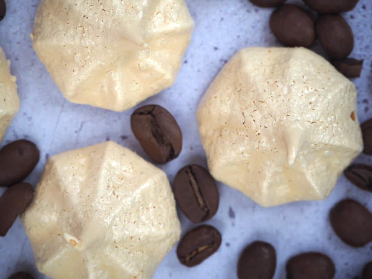 top down view close up of coffee vegan meringues with coffee beans, on a grey background.