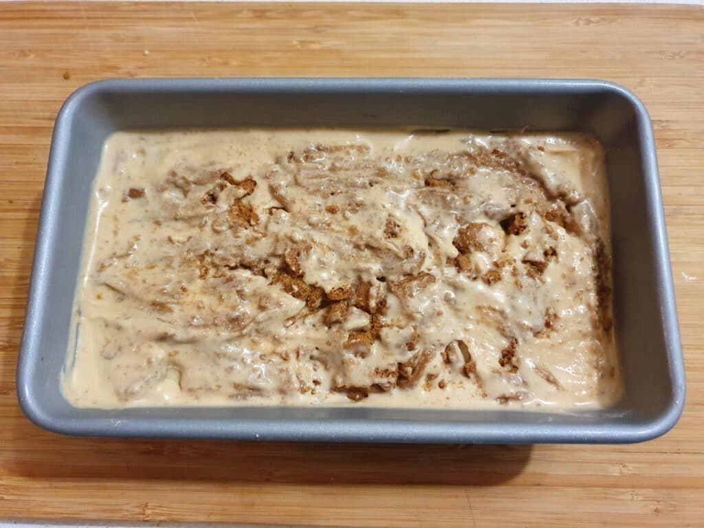 top down view of biscoff ice cream showing spread and crushed biscuits mushed into top layer.