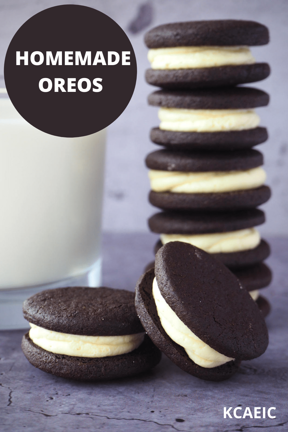 side view of stack of homemade oreos, with single oreo and one oreo propped on its side, with glass of milk and text overlay, homemade oreos and KCAEIC.
