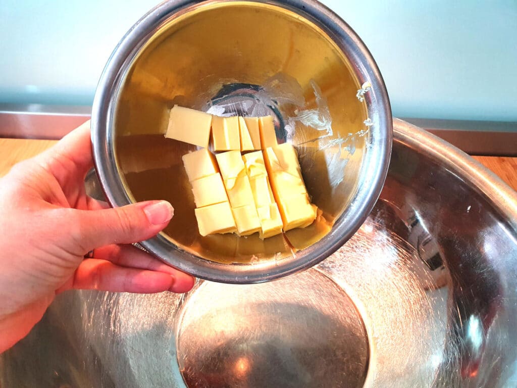 adding butter to mixing bowl.