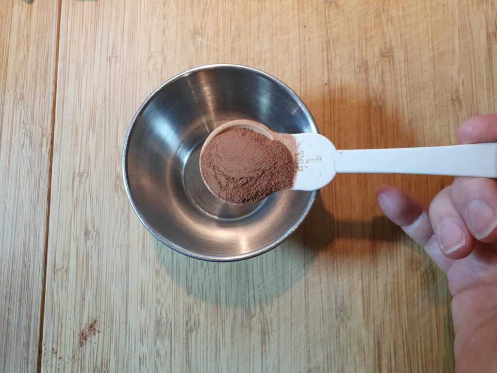 measuring cinnamon into a small bowl.
