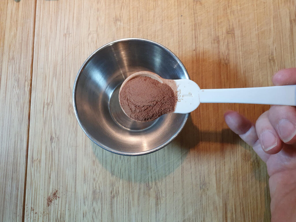 Homemade cola 8 measuring cinnamon into a small bowl.