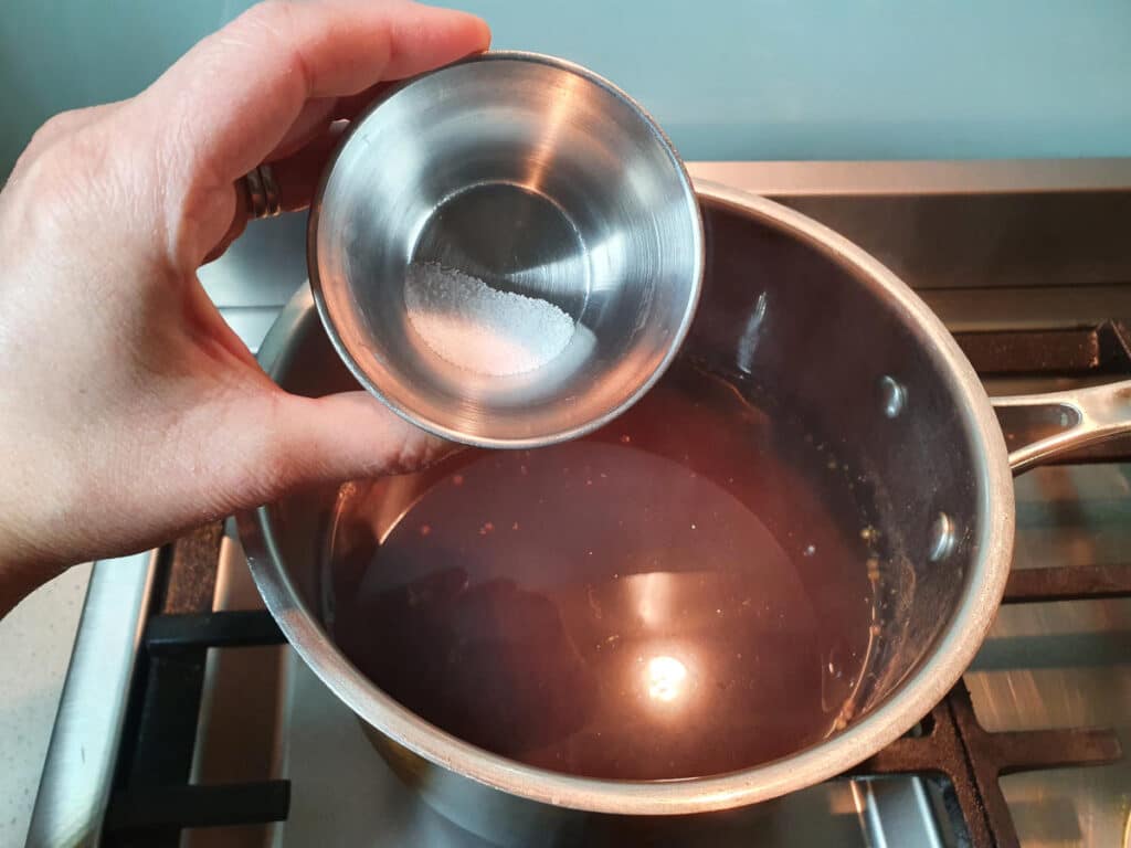 Homemade cola 14 adding citric acid to pot.
