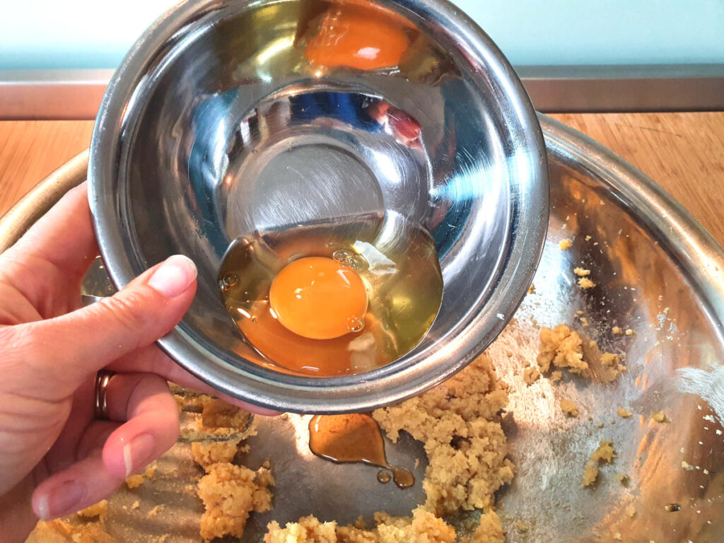 adding egg to butter, sugar and vanilla in a metal mixing bowl.