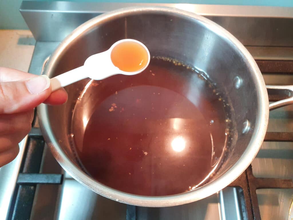 Homemade cola 15 adding vanilla to saucepan.