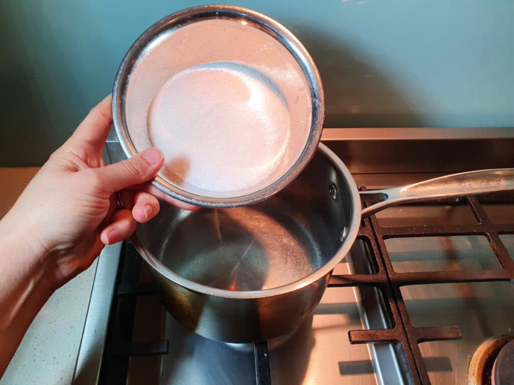 Homemade cola 5 adding white sugar to saucepan.