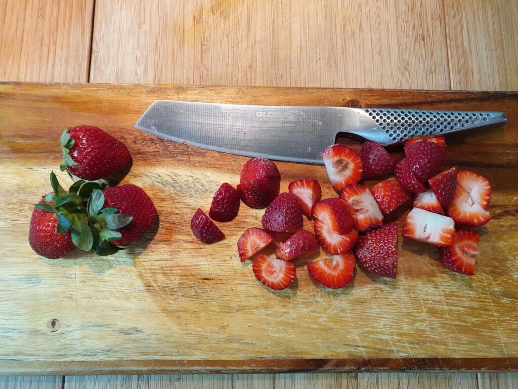 Strawberry ice cream 13 chopping strawberries with sharp knife.