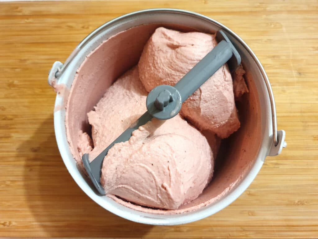 churned ice cream in churning bowl on a chopping board.