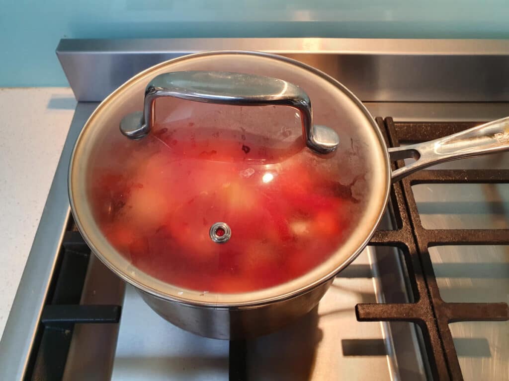 cooking strawberries in pot with lid on.
