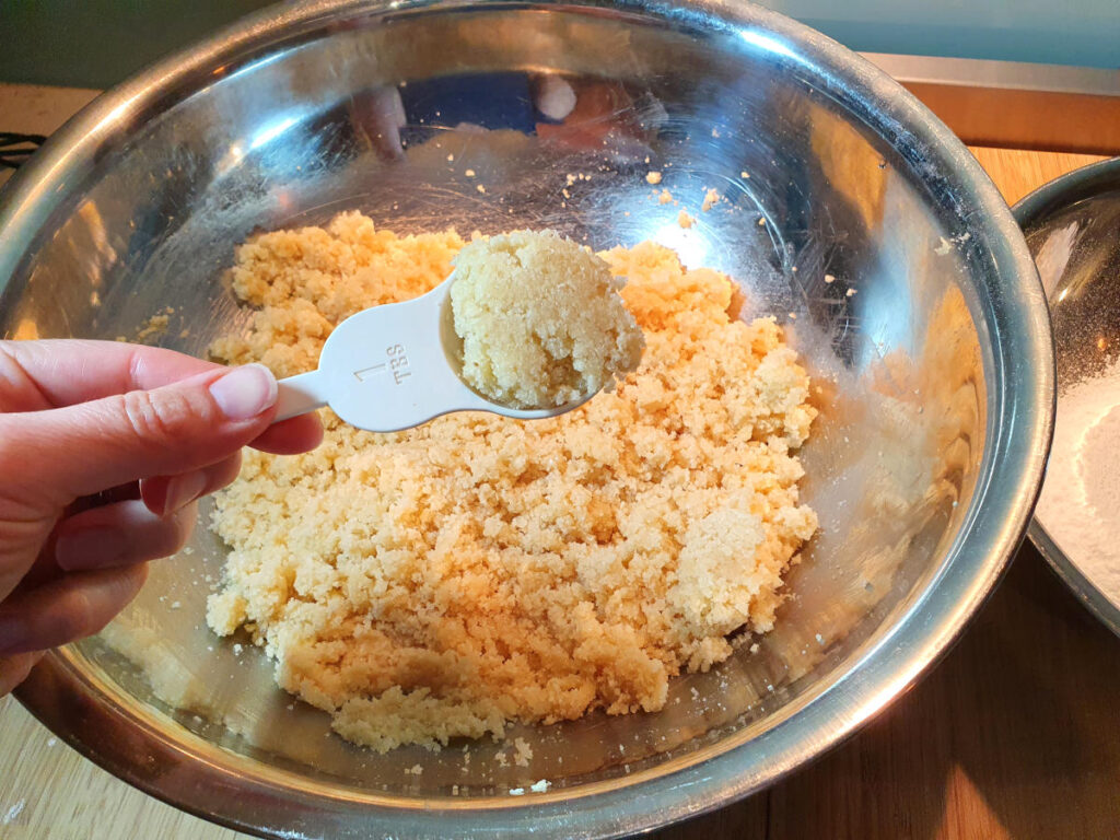 Amaretti cookies 11 meauring out one table spoon of cookie mixture.