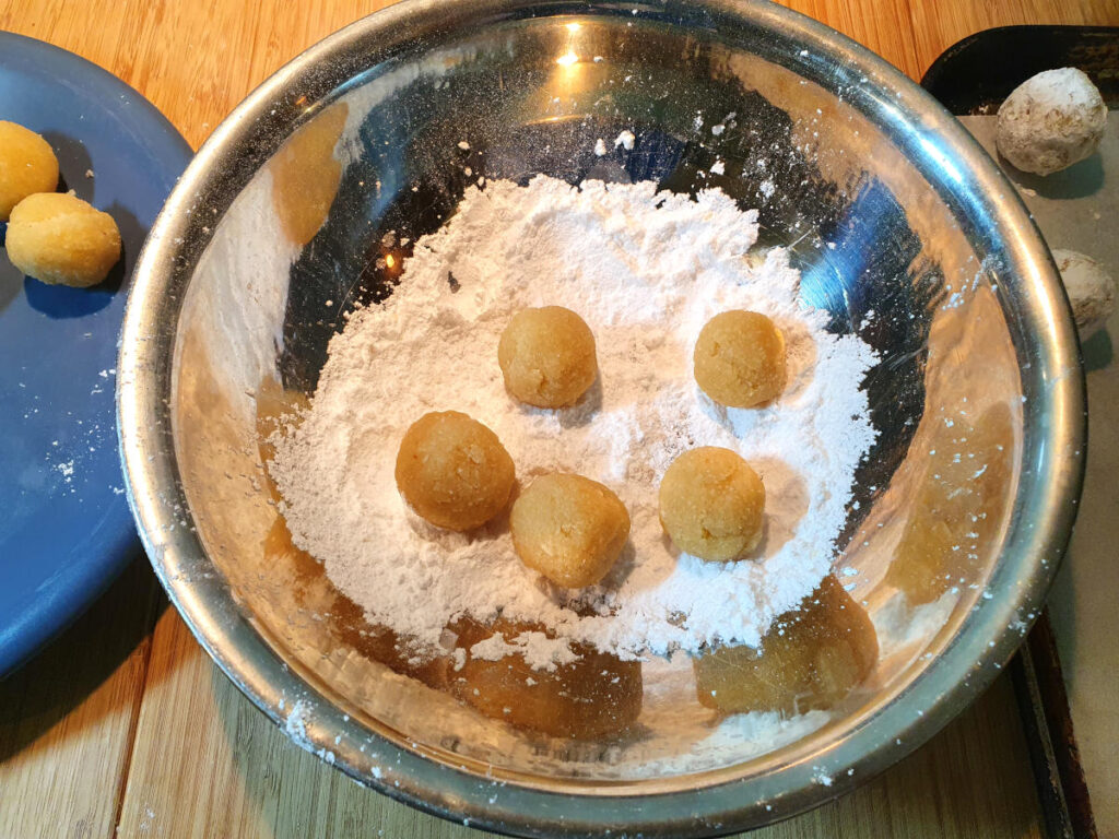 Amaretti cookies 13 rolling multiple cookies in sifted icing sugar.
