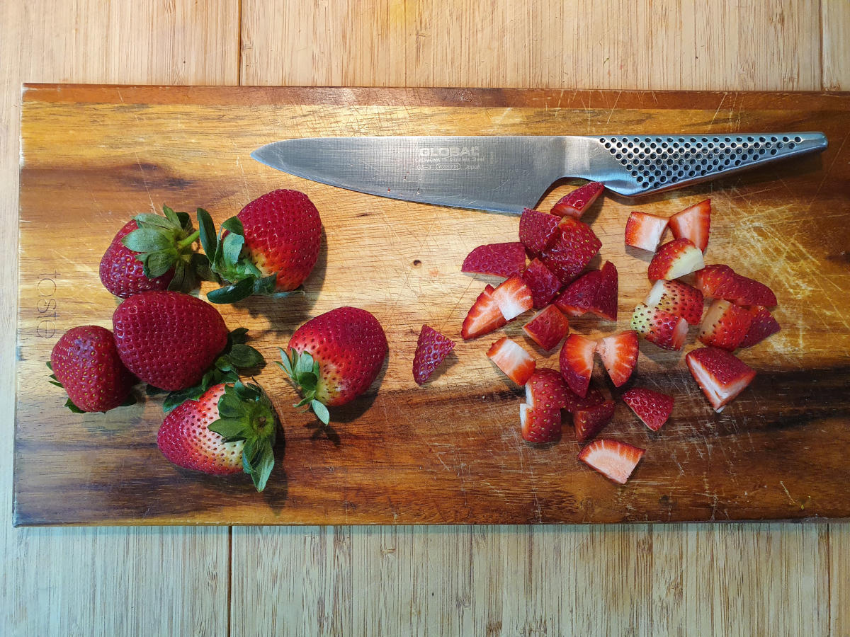 Strawberry yogurt popsicles 4 slicing up strawberries.