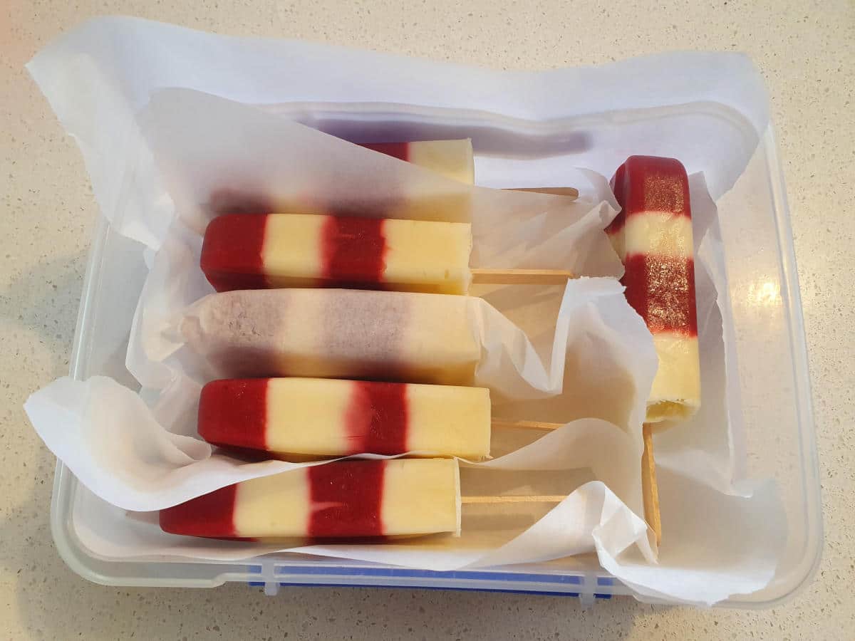storing popsicles in an airtight container lined with baking paper, with baking paper between each popsicle to stop them sticking together.
