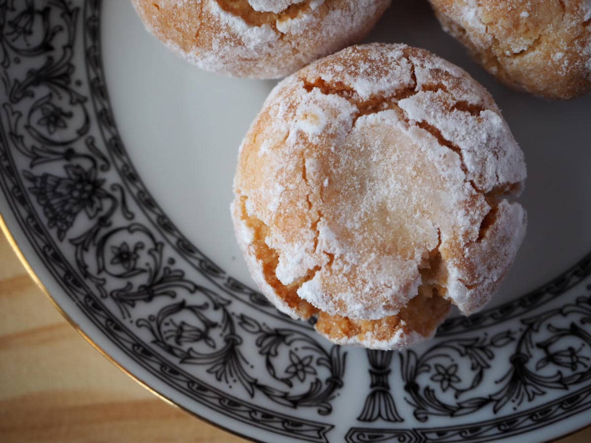 close up top down view of amaretti cookies on a patterned plate.