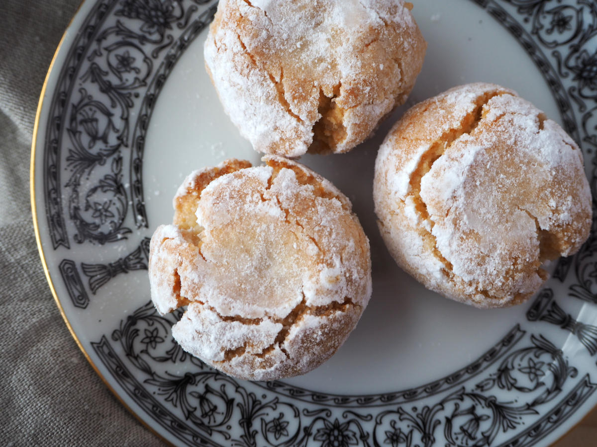 top down view of amaretti cookies on a plate with a tea towel.