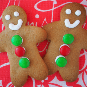 pair of decorated gingerbread med on a red Christmas serviette.