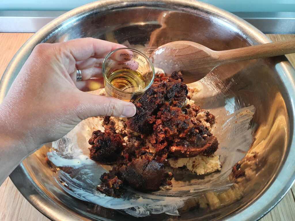 Christmas pudding ice cream 7 adding brandy to pudding in bowl.