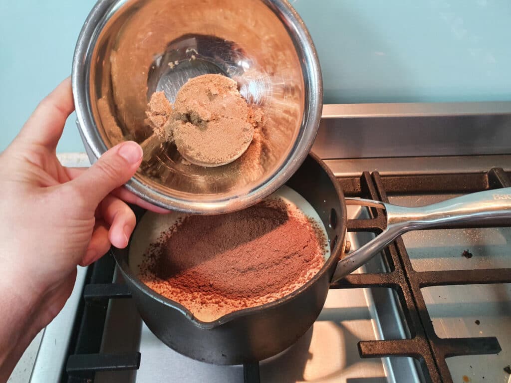 Milo ice cream 7 adding brown sugar to ice cream mix in pot on stove.