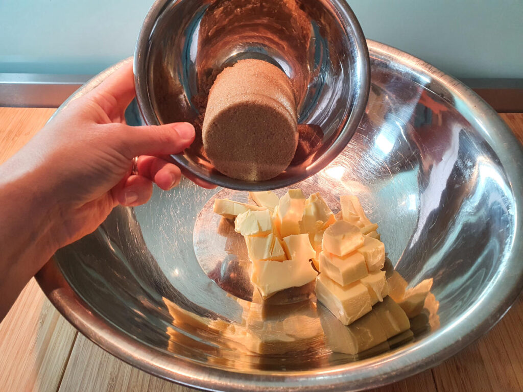 adding brown sugar to room temperature butter in a large mixing bowl.