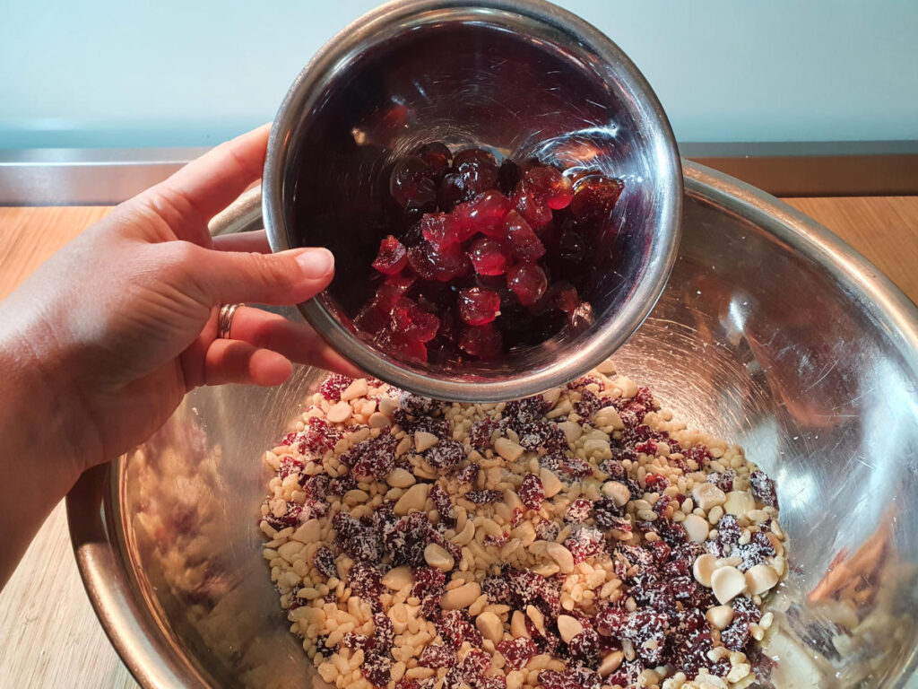 adding chopped cherries to mix in bowl.