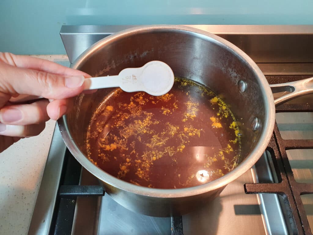 adding citric acid to cola mix in pot.