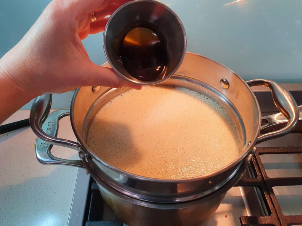 adding golden syrup to ice cream mix in double boiler on stove.