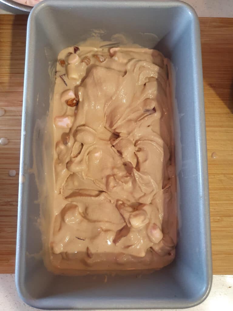 add half of churned chocolate ice cream to first layer in chilled ice cream storage container.