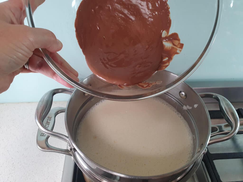 adding melted milk chocolate to ice cream mix in double boiler, about a third at a time.